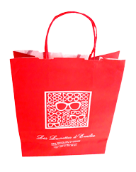 un sac kraft rouge avec des poignées torsadées sérigraphié en blanc avec une impression représentant des paires de lunettes